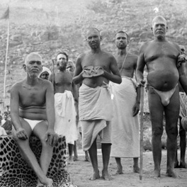 Dandapani Swami (standing on the right) with Bhagavan in the mid-1920s. Muruganar is standing behind him, to his right.