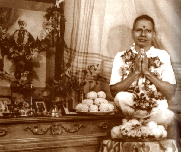 Nisargadatta Maharaj next to the altar that contained the picture of his Guru
