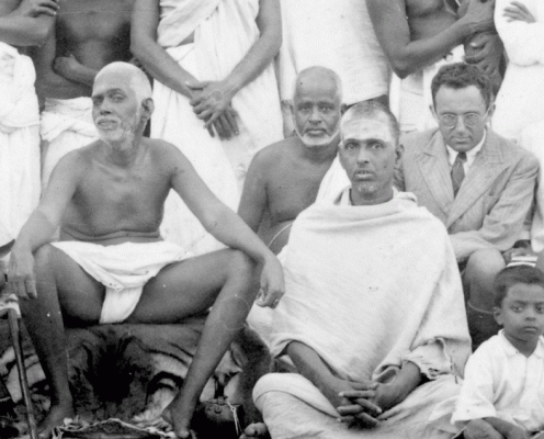 Frydman (wearing a suit) sitting in a 1930s group photo with Ramana Maharshi.